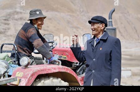 (210613) -- LHASA, 13 giugno 2021 (Xinhua) -- Migmar (R) parla con il suo vicino a Lhaya Village, Gyamco Township, Namling County of Xigaze City, regione autonoma del Tibet della Cina sudoccidentale, 18 aprile 2021. Il Migmar, di 79 anni, è nato nella contea di Sa'gya di Xigaze e ora vive nel villaggio di Lhaya. Nel ricordare la sua vita da serf prima della riforma democratica del 1959, Migmar disse: "La mia famiglia era fortemente indebitata in quel periodo, quindi sono stato mandato in gregge per un proprietario di serf a pagare i debiti della mia famiglia quando avevo solo sette anni". Là ha sofferto continuamente di punizioni come Foto Stock