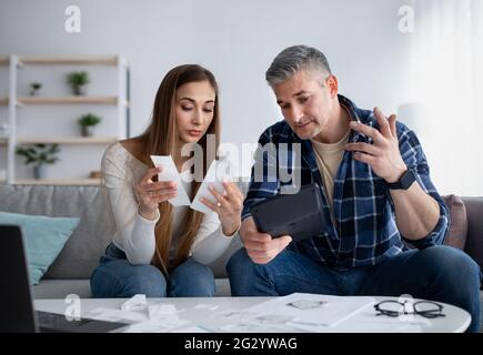 Coppia sposata matura che ha problemi finanziari, nessun denaro per pagare le loro fatture, discutere di reddito, passando attraverso la crisi Foto Stock