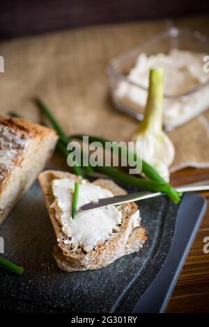 Pane di grano saraceno fatto in casa con formaggio all'aglio spalmato su un legno tabella Foto Stock