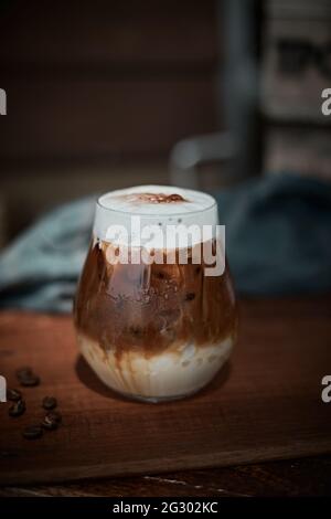 Caffè latte macchiato in una tazza di caffè trasparente. Foto Stock