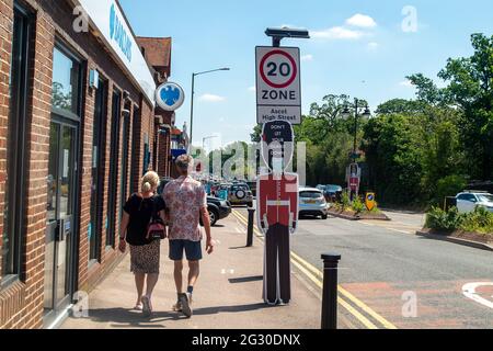 Ascot, Berkshire, Regno Unito. 13 giugno 2021. La gente cammina oltre non lasciare la vostra guardia giù le indicazioni in Ascot High Street. Il numero di risultati positivi di Covid-19 nel Berkshire è in aumento su un tasso giornaliero come la variante indiana di Covid-19 sweep in tutto il Regno Unito. Boris Johnson dovrebbe annunciare domani che la revoca delle restrizioni di blocco di Covid-19 deve essere messa in attesa per un altro mese. Credito: Maureen McLean/Alamy Foto Stock