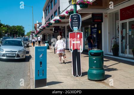 Ascot, Berkshire, Regno Unito. 13 giugno 2021. La gente cammina oltre non lasciare la vostra guardia giù le indicazioni in Ascot High Street. Il numero di risultati positivi di Covid-19 nel Berkshire è in aumento su un tasso giornaliero come la variante indiana di Covid-19 sweep in tutto il Regno Unito. Boris Johnson dovrebbe annunciare domani che la revoca delle restrizioni di blocco di Covid-19 deve essere messa in attesa per un altro mese. Credito: Maureen McLean/Alamy Foto Stock