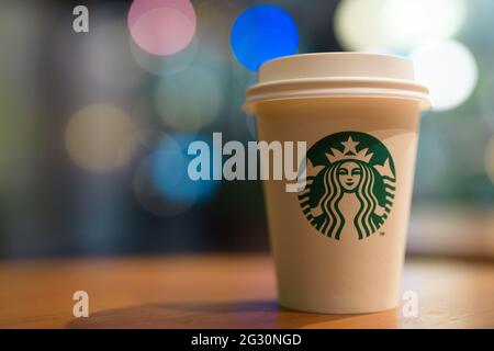 Bangkok, Thailandia - 13 Giugno 2021 : tazza di carta bianca Starbucks su sfondo di tavola di legno con spazio di copia Foto Stock