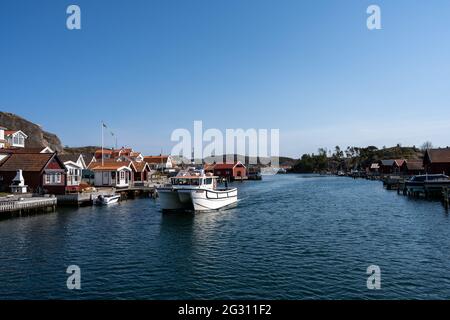 17 aprile 2021 - Hamburgsund, Svezia: Un pittoresco villaggio di pescatori sulla costa occidentale svedese. Tradizionali capanne di mare rosso e un cielo blu sullo sfondo Foto Stock