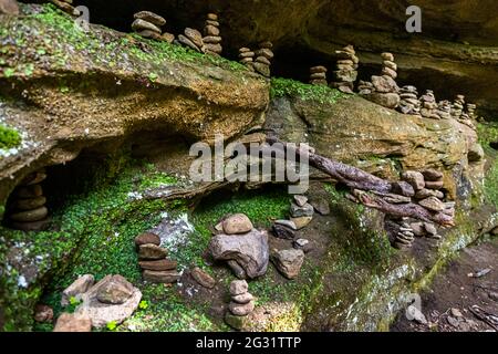 Cairns sul sentiero escursionistico attraverso la valle Mullerthal vicino Berdorf, Lussemburgo. Rocce grandi e piccole. Oltre alle massicce formazioni rocciose, qui si incontrano anche innumerevoli arrangiamenti di cairns Foto Stock