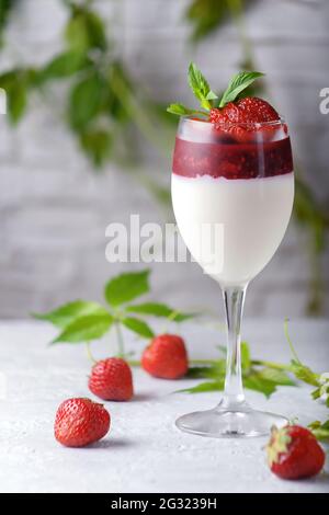 Tradizionale dessert italiano alla vaniglia panna cotta alla fragola in verina con frutti di bosco freschi. Spazio di copia. Foto Stock