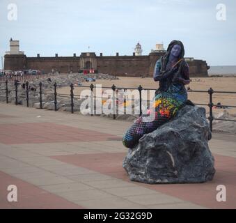 Statua della Sirenetta sulla Marine Parade a New Brighton con Fort Rock perch sullo sfondo progettato dall'artista locale Barry Canning-Eaton Foto Stock