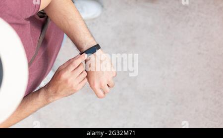 Vista verticale dall'alto di una persona irriconoscibile che indossa il suo orologio intelligente Foto Stock