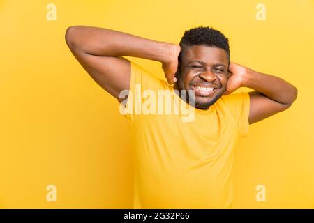 Ritratto di attraente pazzo sorridente afroamericano ragazzo studente in trendy t-shirt giallo orecchie di chiusura evitando scandalo conflitto isolato su Foto Stock