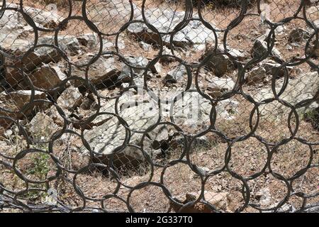 La rete di protezione in acciaio con un design ad anello protegge dalle frane. Contea di sonora, California. Foto Stock