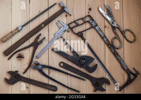 Vista dall'alto di un vecchio utensile su uno sfondo di legno chiaro per l'edificio o il rinnovo. Un set di utensili manuali per l'edilizia. Utensili artigianali. Concetto per fa Foto Stock