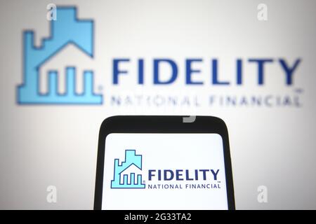 In questa illustrazione fotografica viene visualizzato un logo Fidelity National Financial (FNF) sullo schermo di uno smartphone e di un pc. Foto Stock