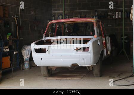 Riparare una vecchia vettura. Parabrezza, lunotto, finestrini laterali rimossi dalla vettura. Foto Stock