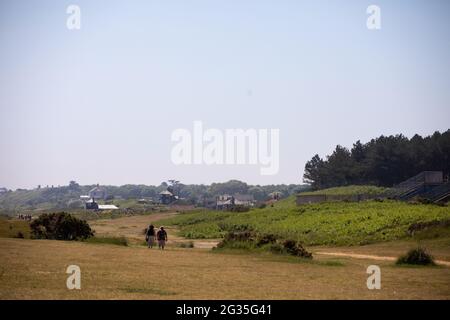 Coppia a piedi a Sizewell Beach, Suffolk, Inghilterra Foto Stock