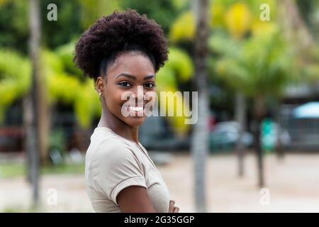 Bella donna caraibica con capelli afro all'aperto in estate in città Foto Stock