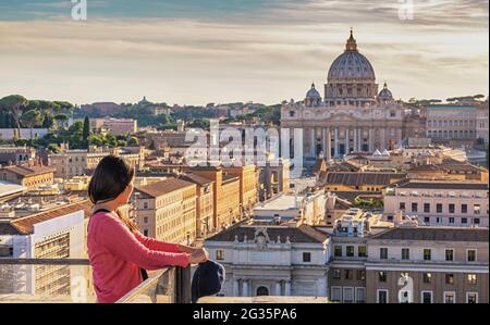 Roma Vaticano Italia vista ad alto angolo tramonto skyline della città con donna turistica Foto Stock