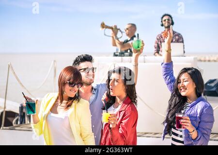 Gente funky ballare musica e divertirsi insieme alla spiaggia rave Afterhour party - Deejay e tromba giocatore intrattenere giovani amici felici Foto Stock