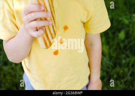 Macchie di ketchup su una t-shirt gialla. La vita quotidiana macchia sporca per il lavaggio e la pulizia concetto. Foto Stock