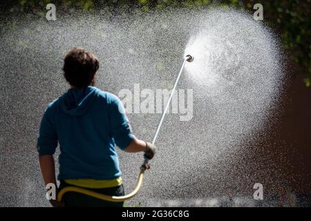 Magonza, Germania. 14 Giugno 2021. Un giardiniere della città di Magonza bagna un letto di fiori nel centro della città. Nella prossima settimana si suppone che sia superiore a 30 gradi in Renania-Palatinato. Credit: Sebastian Gollnow/dpa/Alamy Live News Foto Stock