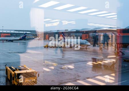 Mosca. Russia. 12/20/2020. Manutenzione degli aeromobili all'aeroporto di Sheremetyevo. Aeroflot. Ural Airlines. Vista attraverso il vetro dell'aeroporto con riflessi Foto Stock