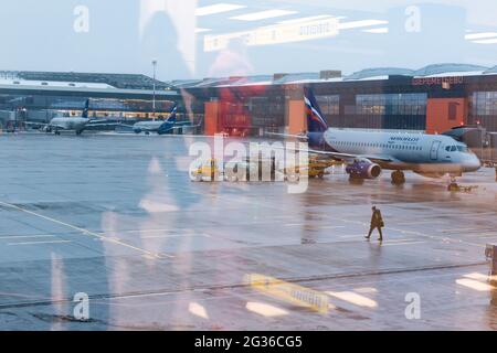 Mosca. Russia. 12/20/2020. Manutenzione degli aeromobili all'aeroporto di Sheremetyevo. Aeroflot. Ural Airlines. Vista attraverso il vetro dell'aeroporto con riflessi Foto Stock