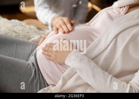 Primo piano medico che tocca la pancia della donna incinta, controllo medico Foto Stock