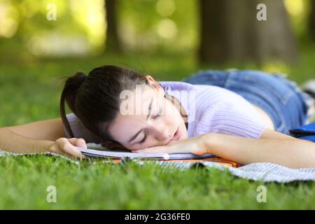 Studente stanco che dormiva su un notebook in un parco o in un campus Foto Stock