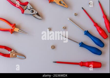 Disposizione piatta di set di attrezzi per la riparazione di automobili e la manutenzione domestica su sfondo grigio. Vista dall'alto Foto Stock