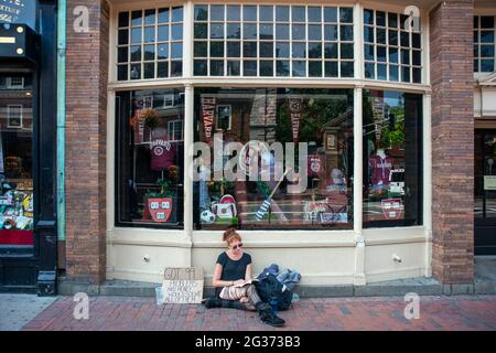 Giovane ragazza senza casa all'Università di Harvard T-shirt libri e negozio di souvenir nel centro della città Massachusetts Avenue, Cambridge, Massachusetts, Stati Uniti Foto Stock