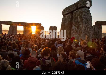 I primi raggi di sole entrano nel cerchio interno del monumento neolitico Stonehenge sulla piana di Salisbury il giorno del solstizio. Inghilterra, Regno Unito. Foto Stock