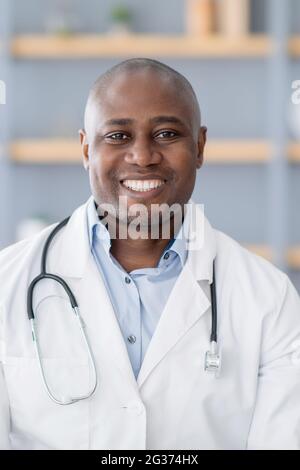 Assistenza sanitaria a distanza. Ritratto di medico afroamericano in camice bianco con stetoscopio in ufficio interno, raccolto Foto Stock