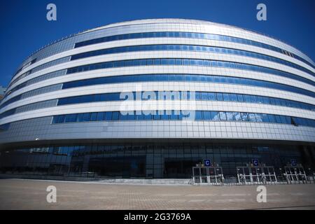 Il nuovo edificio del complesso sportivo contro il cielo blu. Finestre di vetro e il cielo nelle nuvole. Foto Stock