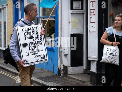 Estinzione ribellione vecchio protestore che parla ad una ragazza giovane che sostiene la plastica anti per la campagna dei mari che l'espressione dice che non è entusiasta! Foto Stock