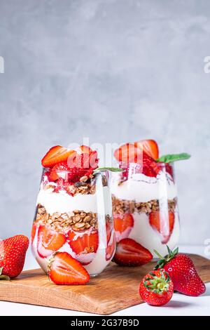 Colazione salutare con fragole preparate con fragole fresche, yogurt e muesli in bicchieri. Foto Stock