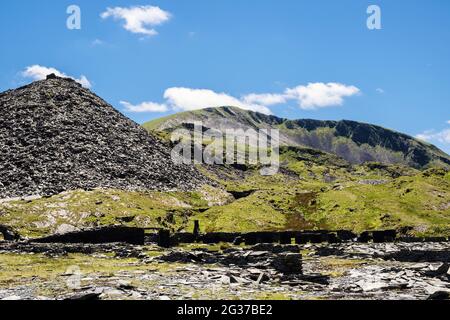 Vecchie rovine derelict e mucchio di scorie alla cava di ardesia di Rhosydd con Moelwyn Mawr Beyond nel Parco Nazionale di Snowdonia. Croesor Bleanau Ffestiniog Gwynedd Galles Foto Stock