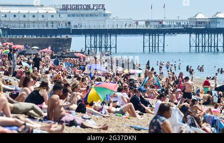 Brighton UK 14 giugno 2021 - le folle godono il sole caldo sulla spiaggia di Brighton oggi come le temperature sono previste per raggiungere il centigradi alto 20s nel sud-est ancora: Credit Simon Dack / Alamy Live News Foto Stock