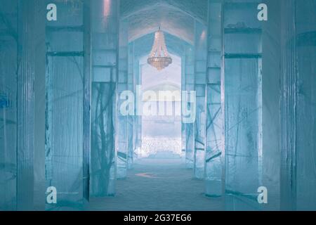 Lungo corridoio con tavolo e lampadario di ghiaccio nel Ice Hotel di Jukkasjaervi, Kiruna, Lapponia, Svezia settentrionale, Svezia Foto Stock