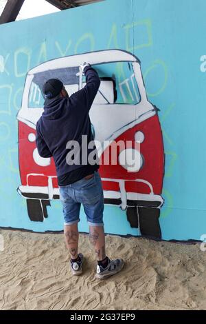 Graffitimaler spray VW bus, Bulli, su una parete blu con primer, Duisburg, Nord Reno-Westfalia, Germania Foto Stock