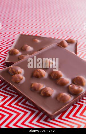 Colpo verticale due pezzi di barretta di cioccolato con nocciole. Foto Stock