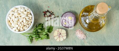 banner con vista dall'alto su fagioli di wite in piatto bianco con cipolla, prezzemolo e sale rosa. ricetta, composizione alimentare, concetto nutrizionale. fagioli di wite w Foto Stock