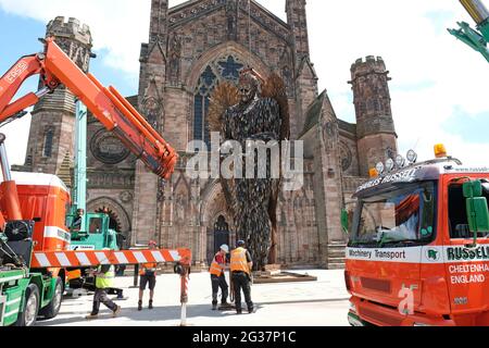 Hereford, Herefordshire, Regno Unito - Lunedi 14 giugno 2021 - i appaltatori iniziano il processo di sollevamento e installazione della statua dell'angelo del coltello fuori della cattedrale - la statua alta 3.5 metri è composta da 100,000 coltelli confiscati ed è stata creata dallo scultore Alfie Bradley. La statua dell'Angelo dei coltelli aumenta la consapevolezza dell'impatto del crimine dei coltelli e sarà esposta all'esterno della cattedrale di Hereford fino al 12 luglio 2021. Photo Steven May / Alamy Live News Foto Stock