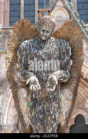 Hereford, Herefordshire, Regno Unito - Lunedi 14 giugno 2021 - la statua dell'angelo del coltello in alto fuori della cattedrale sostenuta da una cornice - la statua di 3.5 tonnellate di altezza 27 piedi è fatta di 100,000 coltelli confiscati ed è stata creata dallo scultore Alfie Bradley. La statua dell'Angelo dei coltelli aumenta la consapevolezza dell'impatto del crimine dei coltelli e sarà esposta all'esterno della cattedrale di Hereford fino al 12 luglio 2021. Photo Steven May / Alamy Live News Foto Stock