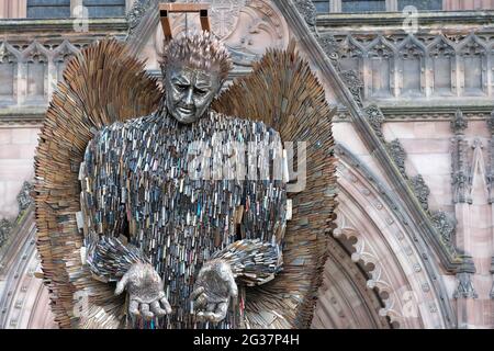 Hereford, Herefordshire, Regno Unito - Lunedi 14 giugno 2021 - la statua dell'angelo del coltello in alto fuori della cattedrale sostenuta da una cornice - la statua di 3.5 tonnellate di altezza 27 piedi è fatta di 100,000 coltelli confiscati ed è stata creata dallo scultore Alfie Bradley. La statua dell'Angelo dei coltelli aumenta la consapevolezza dell'impatto del crimine dei coltelli e sarà esposta all'esterno della cattedrale di Hereford fino al 12 luglio 2021. Photo Steven May / Alamy Live News Foto Stock