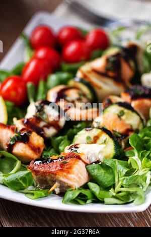 Spiedini di pesce con insalata mista. Foto di alta qualità. Foto Stock