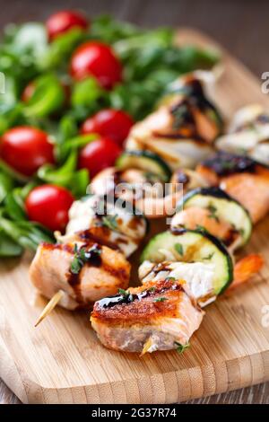 Spiedini di pesce con insalata mista. Foto di alta qualità. Foto Stock