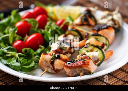 Spiedini di pesce con insalata mista. Foto di alta qualità. Foto Stock