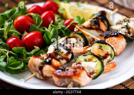 Spiedini di pesce con insalata mista. Foto di alta qualità. Foto Stock