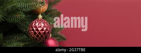 Banner con decorazioni natalizie alla moda. Ornamenti di Capodanno di fronte a sfondo rosso con spazio per la copia. Foto Stock