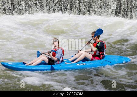 Bath, Regno Unito, 14 giugno 2021. Poiché molte parti del Regno Unito godono di un'altra giornata molto calda e soleggiata, due canoisti sul fiume Avon sono raffigurati di fronte a Pulteney Bridge Credit: Lynchpics/Alamy Live News Foto Stock