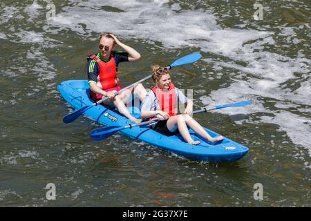 Bath, Regno Unito, 14 giugno 2021. Poiché molte parti del Regno Unito godono di un'altra giornata molto calda e soleggiata, due canoisti sul fiume Avon sono raffigurati di fronte a Pulteney Bridge Credit: Lynchpics/Alamy Live News Foto Stock